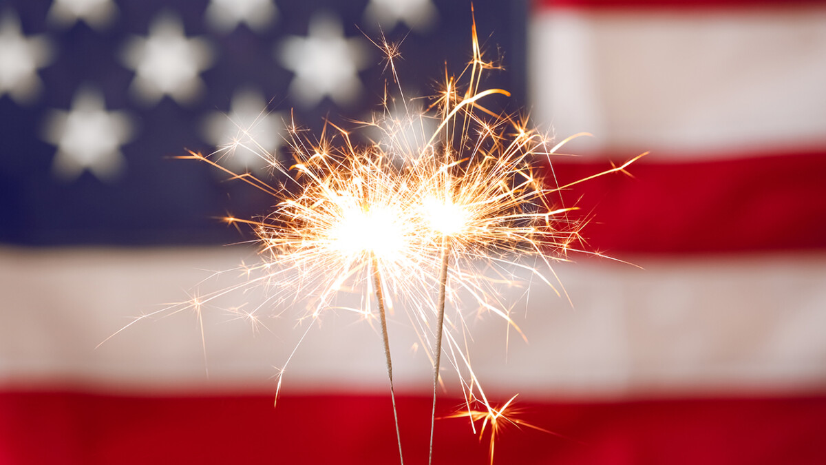 Bright burning sparklers against American flag, closeup